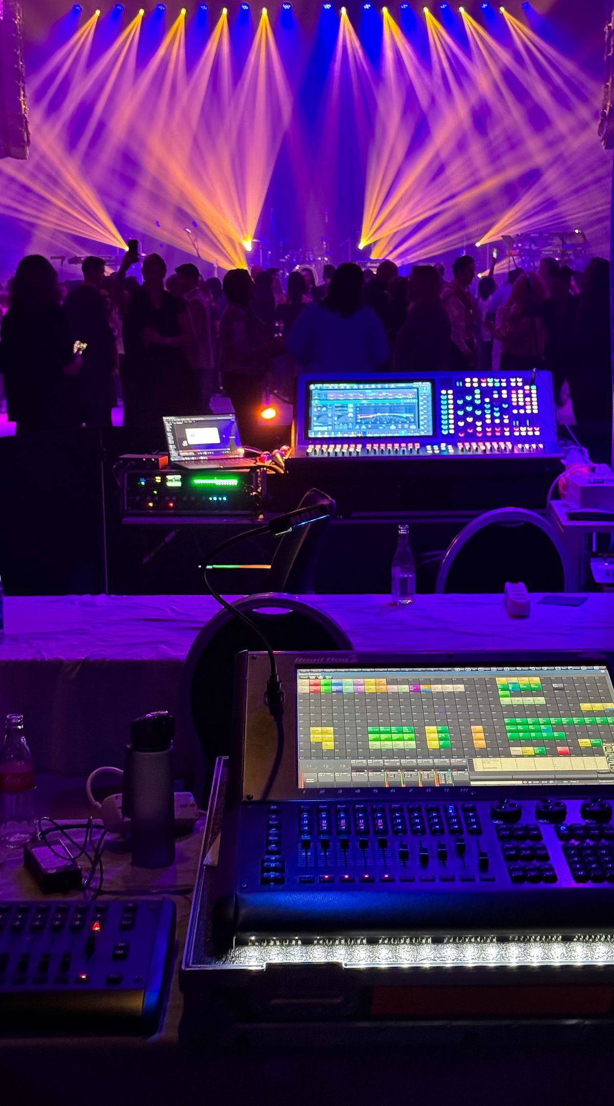Purple and yellow concert lights above a crowd, photographed by Damir K